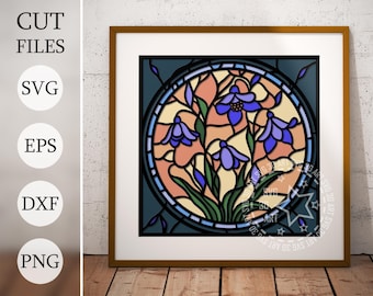 May include: A stained glass style illustration of a bouquet of blue flowers with green leaves and stems. The flowers are arranged in a circle with a peach and yellow background. The design is framed in a dark blue border.