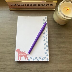 May include: A white notepad with a purple pen and a pink dog silhouette with the text "Love my Lab Partner" on it. The notepad has a blue paw print border.