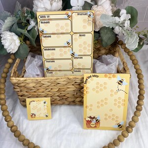 May include: A set of four bee-themed planner stickers. The stickers feature a honeycomb pattern and bees. The stickers are yellow, brown, and black. The stickers are perfect for adding a touch of whimsy to your planner.