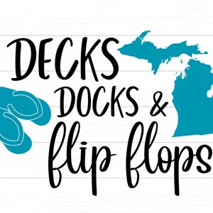 Puede incluir: Un diseño gráfico con el texto "Decks Docks & flip flops" en fuente de letra cursiva negra. El gráfico también incluye un contorno azul del estado de Michigan y un par de chanclas azules.