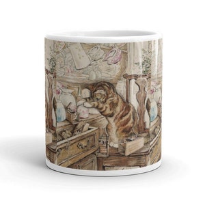 Può includere: Tazza in ceramica bianca con una dettagliata illustrazione di un gatto tigrato che esplora una cassettiera in legno. L'opera d'arte include varie bottiglie, vasi e cassetti, creando un'estetica vintage affascinante. La tazza è di dimensioni standard, circa 325 ml.