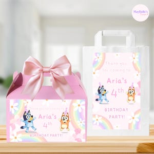 Peut inclure: Une boîte cadeau rose avec un grand nœud en satin et un sac en papier blanc, tous deux ornés d'un arc-en-ciel pastel, de marguerites blanches et de chiens de dessin animé avec le texte : Thank you for coming to Aria's 4th BIRTHDAY PARTY!