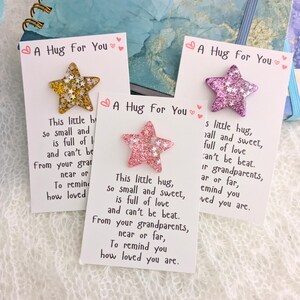 May include: Three white cards with pink and gold glitter stars attached. Each card has the text "A Hug for You" and a short poem about a hug.