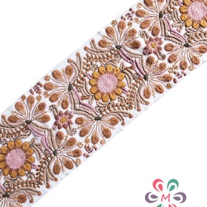 May include: White fabric trim with embroidered brown and pink floral designs. The trim features a repeating pattern of stylized flowers and leaves.