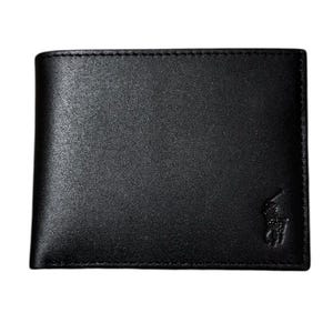 May include: Black leather wallet with a subtle texture. The wallet features a bi-fold design and a small embossed logo on the lower right corner. The stitching around the edges is visible. A classic accessory.