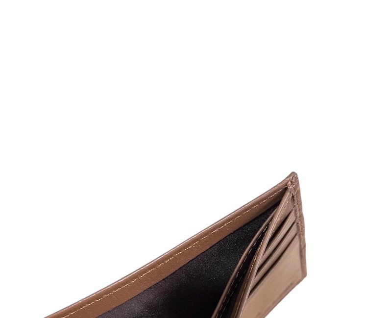May include: An open brown leather wallet with multiple card slots and a billfold. The wallet is empty.