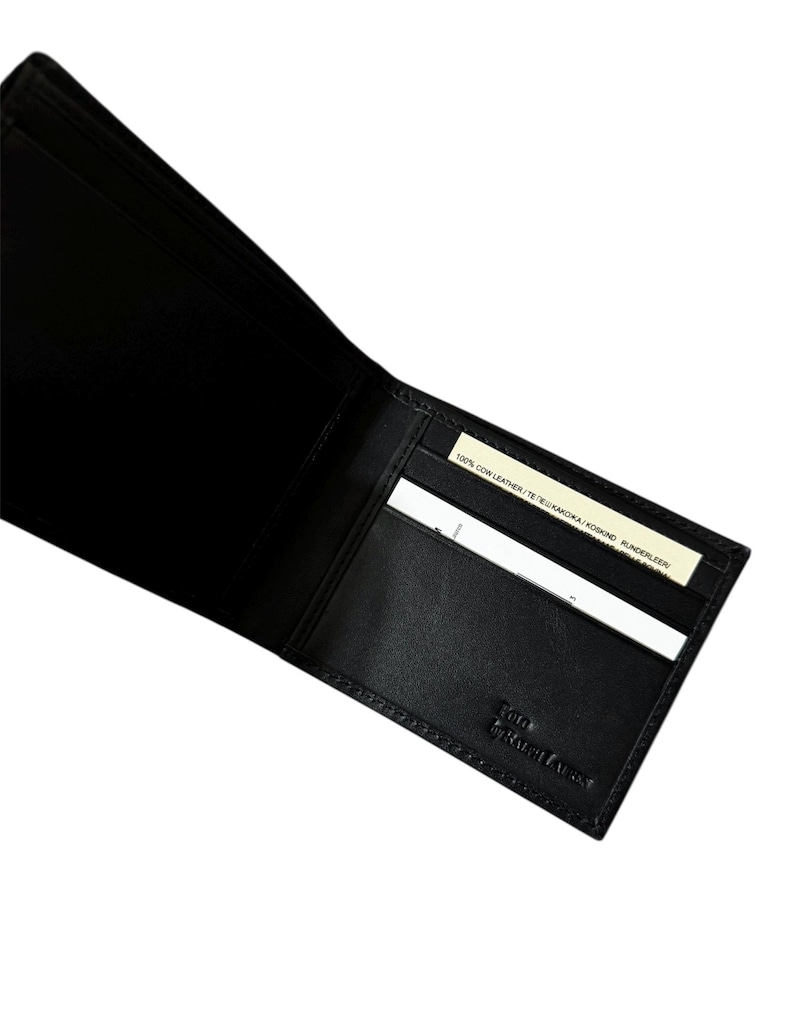 May include: Open black leather wallet with card slots. The wallet is embossed with "POLO by RALPH LAUREN" on the lower right corner. A small tag reads "100% COW LEATHER".