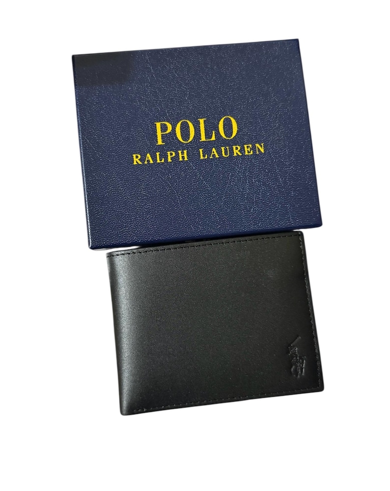 May include: Black leather wallet with a small embossed logo, presented with a navy blue box. The box features the text "POLO RALPH LAUREN" in gold lettering. The wallet is a classic bi-fold design.