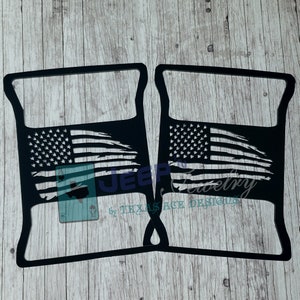 May include: A pair of black metal Jeep Wrangler door handle inserts with a distressed American flag design. The inserts are made by Texas Ace Designs.