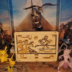 Może przedstawiać: Drewniana scena walki Pokemon z figurką Charizarda i Mewtwo. Scena jest ustawiona jak gra wideo z paskiem menu, na którym widnieje napis "Walcz", "Uciekaj", "Torba" i "Pokemon".