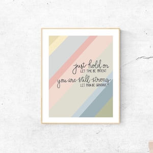 May include: A motivational quote print with a colorful striped background. The quote reads "Just hold on, let time be intent, you are still strong, let pain be guidance."