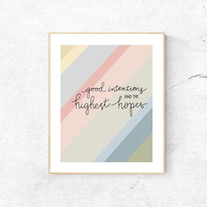 May include: A framed print with a colorful striped background and the text "good intentions and the highest hopes" in black script.