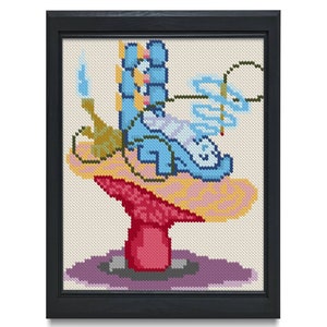 May include: Cross-stitch artwork in a black frame. The image features a whimsical design with a blue shoe, a candle, and abstract shapes on a mushroom-like structure. The color palette includes blue, pink, yellow, and red.