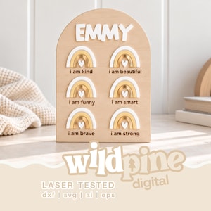 May include: An arched wooden sign featuring the name EMMY in white raised letters at the top. Below are six rainbow icons in white and gold, each paired with the text: i am kind, i am beautiful, i am funny, i am smart, i am brave, and i am strong.