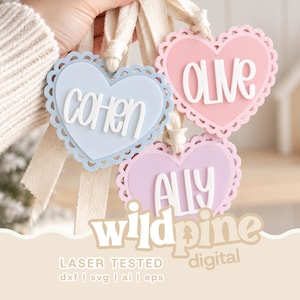Op de afbeelding: Drie hartvormige ornamenten met geschulpte randen in lichtblauw, roze en lavendel. Elk hart is voorzien van witte verhoogde letters met de namen Cohen, Olive en Ally. De ornamenten zijn bevestigd aan crèmekleurige stoffen linten.