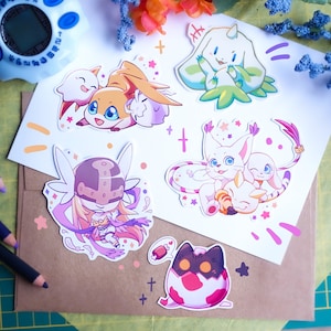 May include: Five colorful cartoon stickers featuring various characters from the Digimon franchise. The stickers are on a white background with pink, purple, and orange accents.