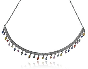 May include: A silver necklace with a curved band of pave set diamonds and a fringe of colorful gemstones.