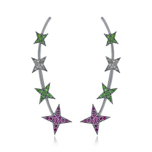 Puede incluir: Un par de pendientes de plata con cinco piedras preciosas en forma de estrella. Las estrellas están engastadas con piedras preciosas verdes, blancas y rosas.