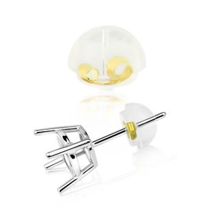 May include: A silver-colored earring post with a four-prong setting, designed to hold a gemstone. A clear, rounded earring back is also visible, along with a gold-colored post holder. The earring is shown against a white background.