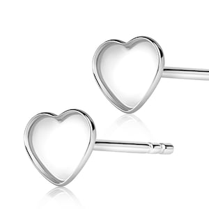 May include: A pair of silver heart-shaped stud earrings. The earrings have a simple, minimalist design.