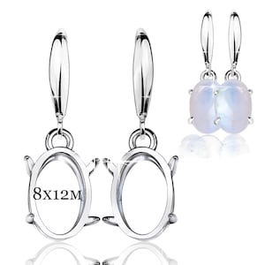 May include: Silver earrings with a lever back. The earrings have an oval setting, with the text "8x12M" inside. One pair features oval, iridescent stones. The setting measures 8mm x 12mm.