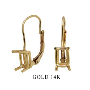 May include: A pair of 14k gold earring settings with a square shape. The settings are designed to hold a gemstone.