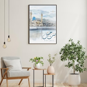Puede incluir: Impresión en acuarela enmarcada de una mezquita con cúpula azul y minaretes, sobre un fondo de montañas y una masa de agua reflectante. Incluye caligrafía árabe y el texto "BINT JBEIL".