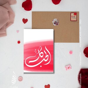 May include: A white calligraphy design of the Arabic word "Habibi" on a red watercolor background. The design is on a white card with a brown envelope.