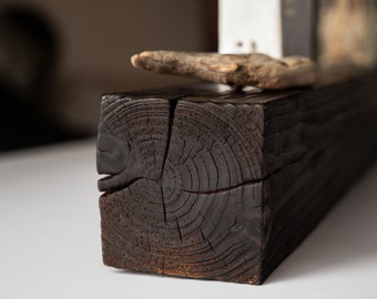 May include: A dark brown wooden shelf with a knot in the center. The shelf is made of reclaimed wood and has a rustic look.