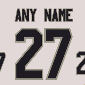 May include: Cream-coloured jersey design featuring the text "ANY NAME" above a large number "27" in black with a grey outline. Two smaller "27" numbers are on either side.