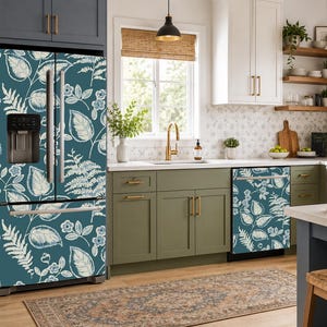 Op de afbeelding: Een koelkast en vaatwasser bedekt met een blauwgroene zelfklevende vinylfolie met een wit botanisch patroon van geschetste bladeren, varens en kleine bloemen, wat zorgt voor een decoratieve afwerking van de keukenapparatuur.