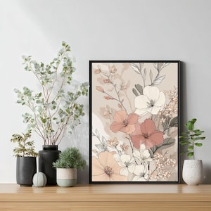 Könnte beinhalten: Gerahmter Kunstdruck mit Blumenmotiv. Das Kunstwerk zeigt einen Blumenstrauß in Pfirsich-, Weiß- und Rosatönen vor beigem Hintergrund. Dekorative Pflanzen und Vasen sind auf einer Holzoberfläche angeordnet.