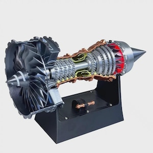 May include: A detailed cross-section model of a jet engine, showcasing internal components. The model features a silver fan, multiple turbine blades, and a red-glowing combustion chamber. It is mounted on a black stand, providing a clear view of the engine's mechanics.