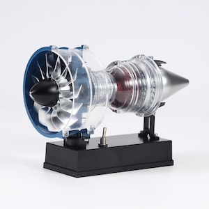 May include: A detailed model of a jet engine, showcasing internal components. The engine features a blue intake ring, transparent casing, and silver and black internal parts. It sits on a black base with a switch.