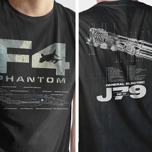Puede incluir: Camiseta negra con un gráfico blanco de un avión F-4 Phantom y el texto "F4 PHANTOM" y "MCDONNELL DOUGLAS F4E/F4J/F4B/F4D/F4S/F4G", y un diagrama del motor del avión con el texto "GENERAL ELECTRIC J79 GE-17".