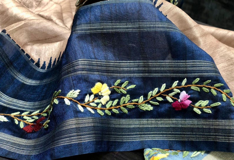Handcrafted Tussar silk saree featuring delicate French knot embroidery with intricate floral detailing, offering a blend of texture, elegance, and artisanal charm.