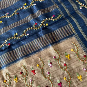 Handcrafted Tussar silk saree featuring delicate French knot embroidery with intricate floral detailing, offering a blend of texture, elegance, and artisanal charm.