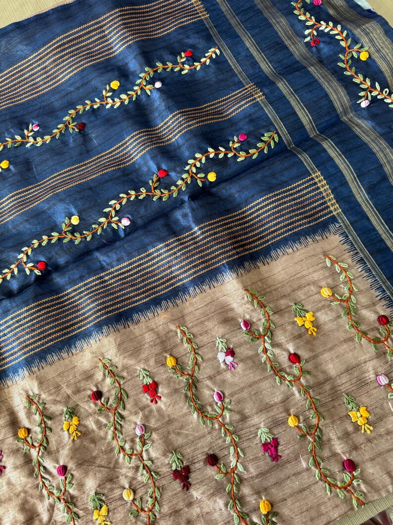 Handcrafted Tussar silk saree featuring delicate French knot embroidery with intricate floral detailing, offering a blend of texture, elegance, and artisanal charm.