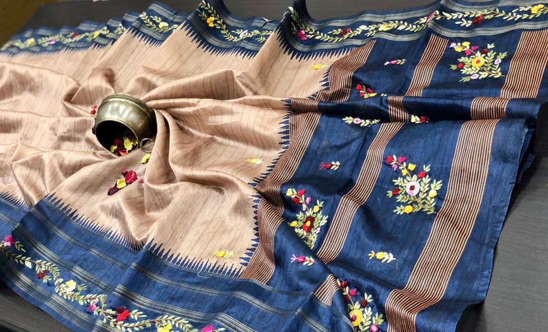 Handcrafted Tussar silk saree featuring delicate French knot embroidery with intricate floral detailing, offering a blend of texture, elegance, and artisanal charm.