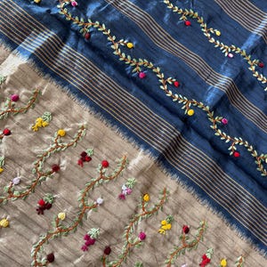 Handcrafted Tussar silk saree featuring delicate French knot embroidery with intricate floral detailing, offering a blend of texture, elegance, and artisanal charm.