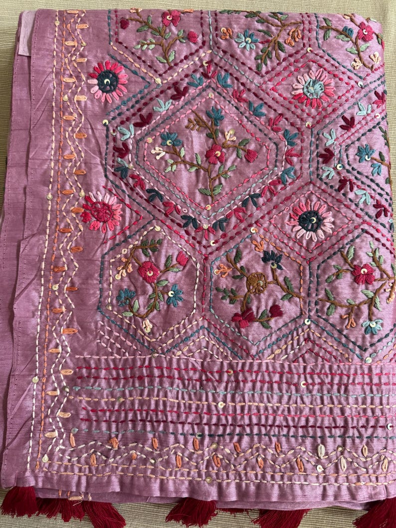 Pink Tussar silk saree featuring intricate Lambani and Kantha floral embroidery, elegant handcrafted ethnic saree with matching blouse piece, perfect for weddings, parties, festive occasions, and traditional celebrations.