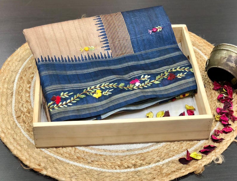 Handcrafted Tussar silk saree featuring delicate French knot embroidery with intricate floral detailing, offering a blend of texture, elegance, and artisanal charm.
