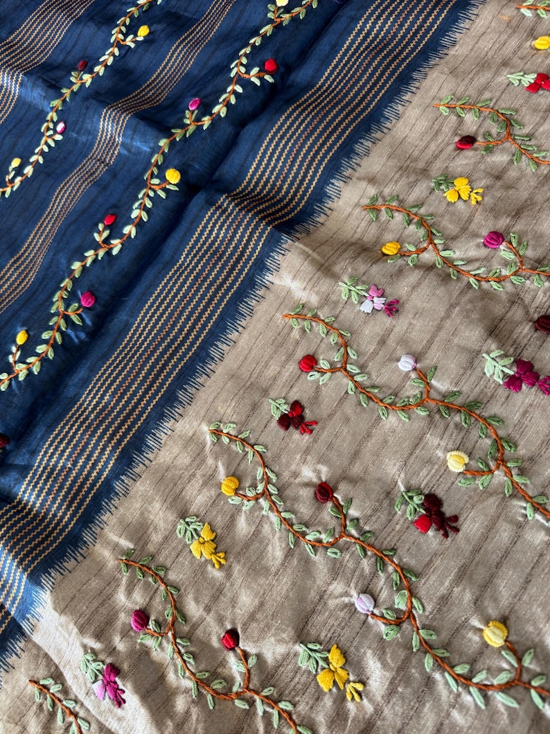 Handcrafted Tussar silk saree featuring delicate French knot embroidery with intricate floral detailing, offering a blend of texture, elegance, and artisanal charm.