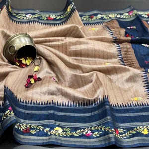 Handcrafted Tussar silk saree featuring delicate French knot embroidery with intricate floral detailing, offering a blend of texture, elegance, and artisanal charm.