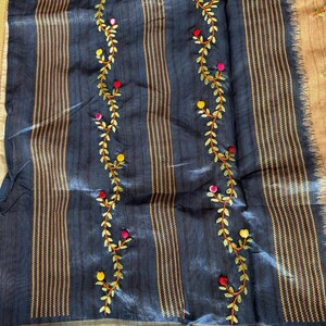Handcrafted Tussar silk saree featuring delicate French knot embroidery with intricate floral detailing, offering a blend of texture, elegance, and artisanal charm.