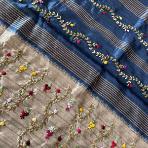 Handcrafted Tussar silk saree featuring delicate French knot embroidery with intricate floral detailing, offering a blend of texture, elegance, and artisanal charm.