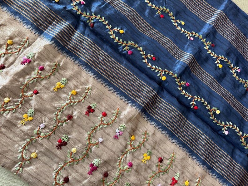 Handcrafted Tussar silk saree featuring delicate French knot embroidery with intricate floral detailing, offering a blend of texture, elegance, and artisanal charm.