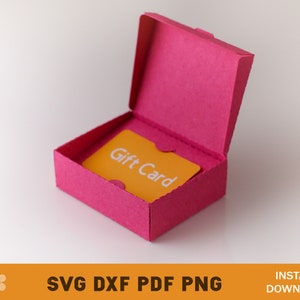 Puede incluir: Una caja de regalo rosa con una tarjeta de regalo amarilla en su interior. La tarjeta de regalo dice "Gift Card".