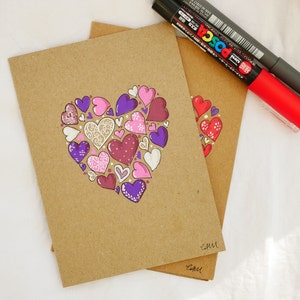 Cartão de dia dos namorados desenhado à mão, corações rosa e roxo. Desenho original, cartão de arte exclusivo, não é uma impressão. Marcadores de tinta em kraft.