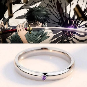 May include: A silver band ring with a small, light purple gemstone set in the center.